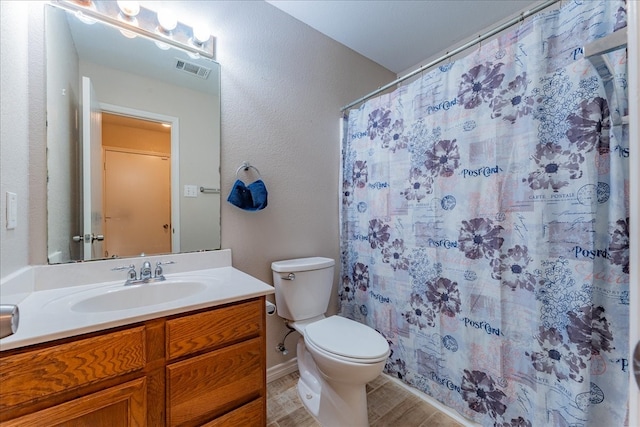 bathroom featuring vanity, toilet, and walk in shower