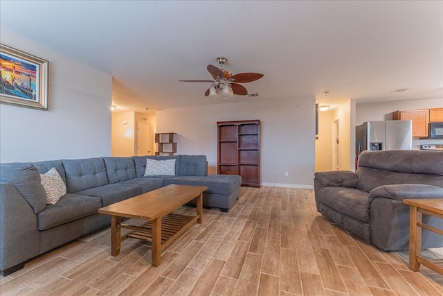 living room with light hardwood / wood-style flooring and ceiling fan