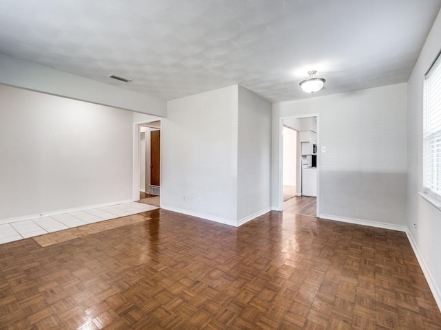 spare room with dark parquet floors