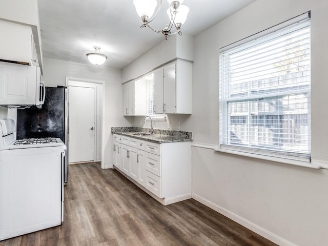 kitchen with white appliances, sink, dark hardwood / wood-style floors, a notable chandelier, and white cabinetry