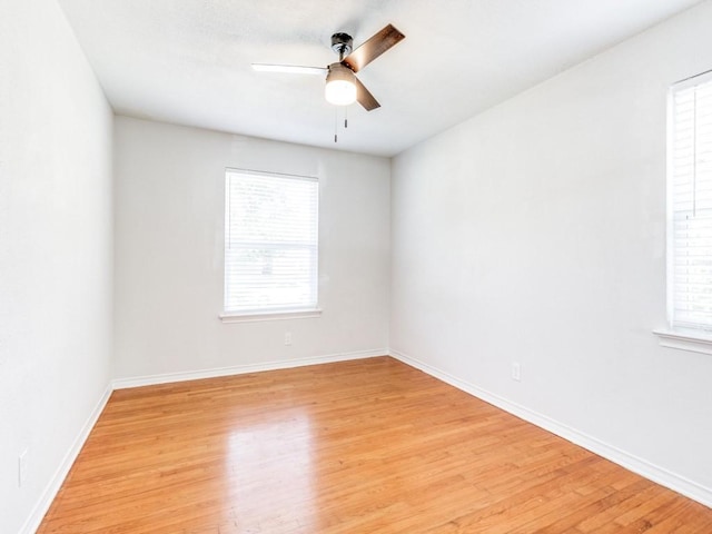 spare room featuring ceiling fan, a wealth of natural light, and light hardwood / wood-style flooring