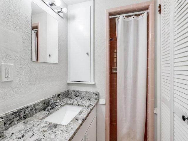 bathroom featuring curtained shower and vanity