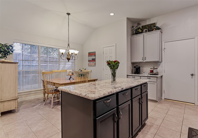 kitchen featuring gray cabinetry, pendant lighting, light tile patterned flooring, vaulted ceiling, and a kitchen island