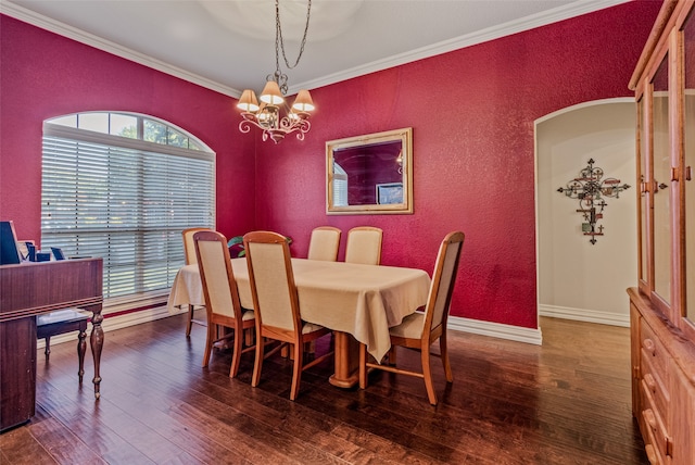 dining area with crown molding, dark wood-type flooring, and an inviting chandelier