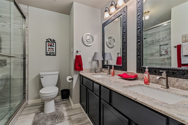 bathroom featuring vanity, toilet, and an enclosed shower