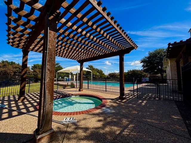 view of swimming pool featuring a community hot tub, a pergola, and a patio area