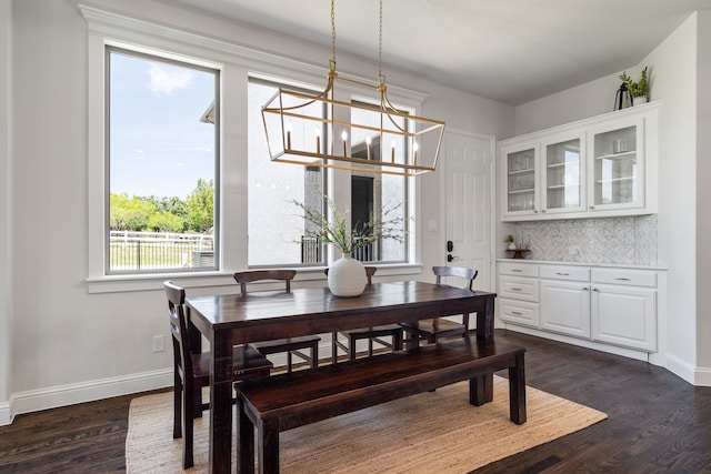 dining space with dark wood-type flooring and a notable chandelier