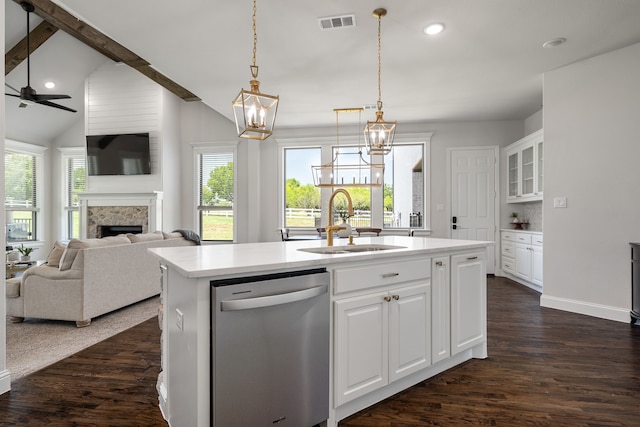 kitchen featuring sink, stainless steel dishwasher, an island with sink, a fireplace, and white cabinets