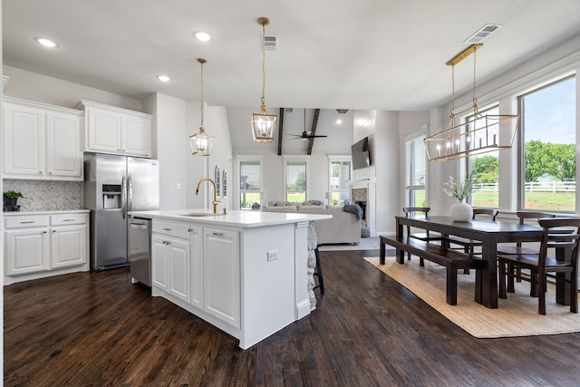 kitchen with white cabinetry, dark hardwood / wood-style flooring, ceiling fan, and stainless steel appliances