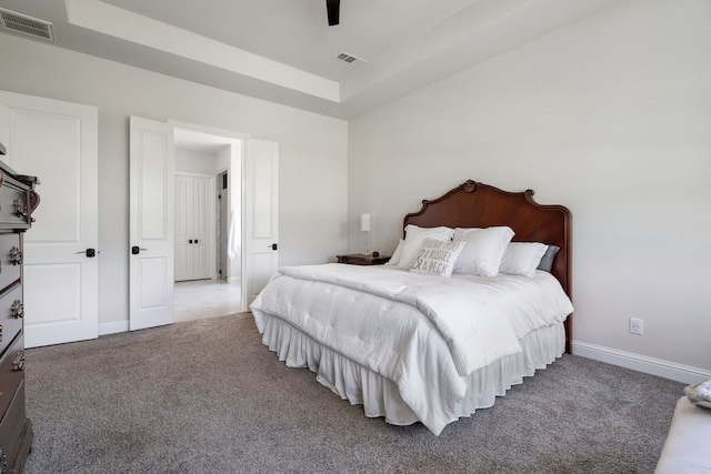 bedroom featuring carpet floors, a raised ceiling, and ceiling fan