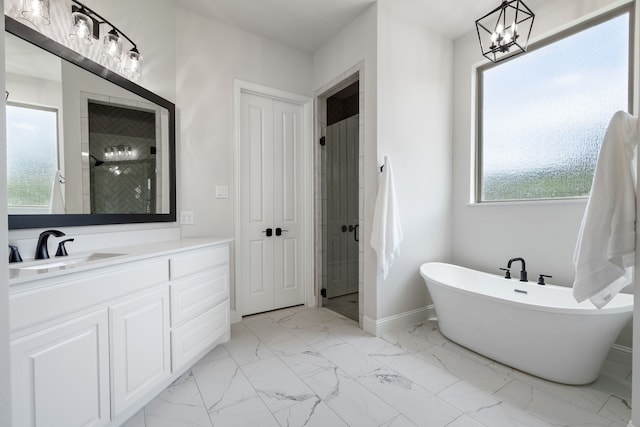 bathroom featuring separate shower and tub, vanity, and a chandelier