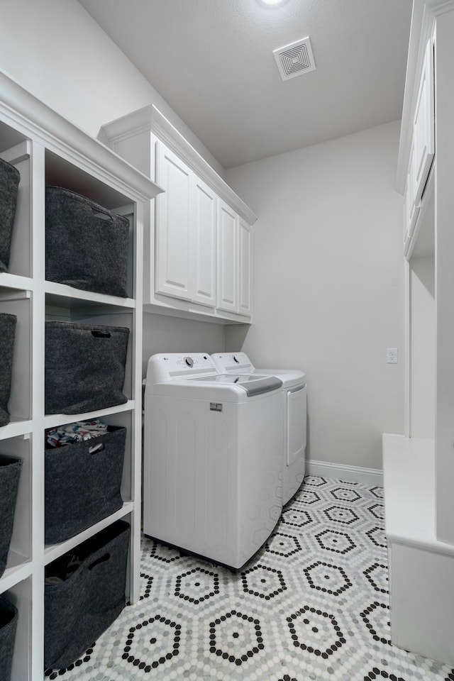 laundry room featuring cabinets and washing machine and dryer