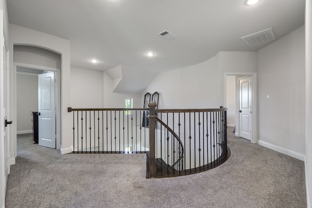 hall with carpet flooring and vaulted ceiling