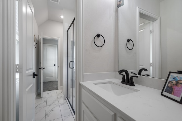 bathroom featuring vanity, a shower with shower door, and vaulted ceiling