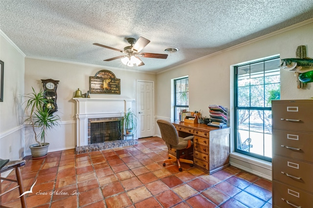 office area featuring crown molding, ceiling fan, a textured ceiling, and a brick fireplace