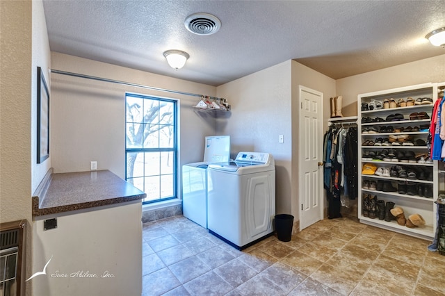 laundry room featuring a textured ceiling and washer and clothes dryer