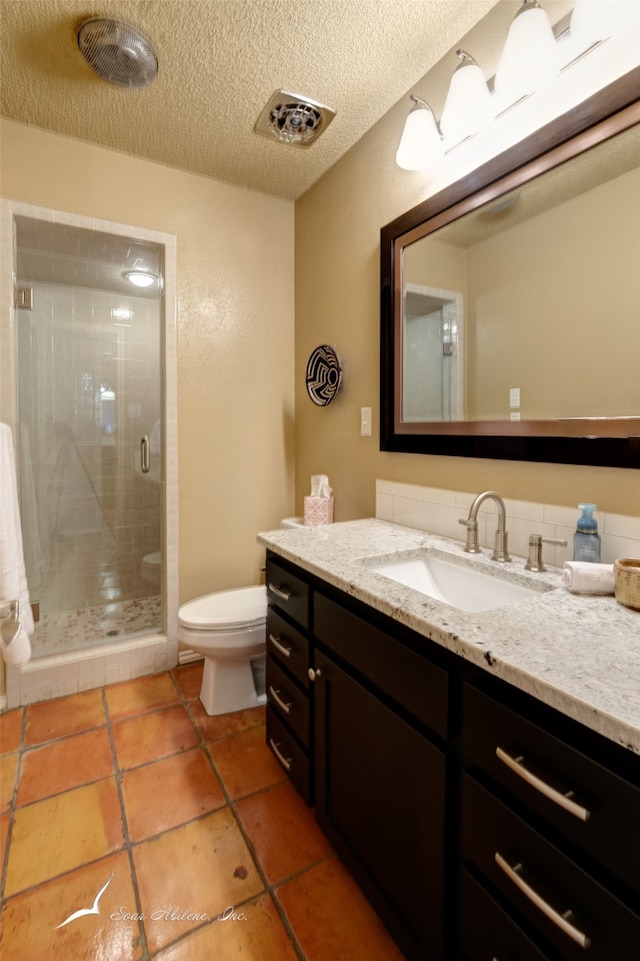 bathroom featuring tile patterned floors, a textured ceiling, vanity, toilet, and a shower with shower door