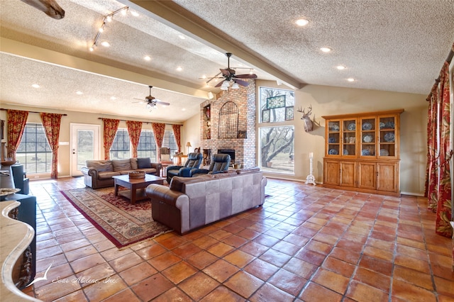 living room with vaulted ceiling with beams, a fireplace, a textured ceiling, and ceiling fan