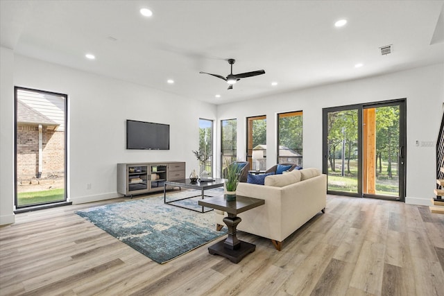 living room with ceiling fan and light hardwood / wood-style flooring