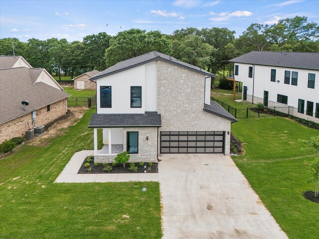 view of front of home with cooling unit, a front lawn, and a garage