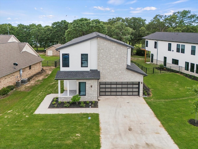 view of front of house featuring a garage, a front lawn, and central air condition unit