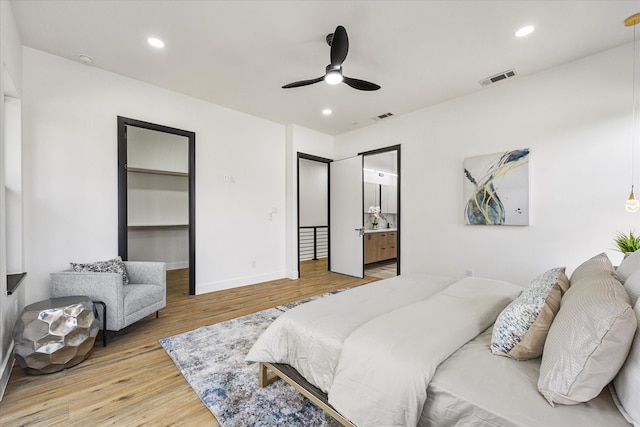 bedroom with ensuite bath, ceiling fan, and light wood-type flooring