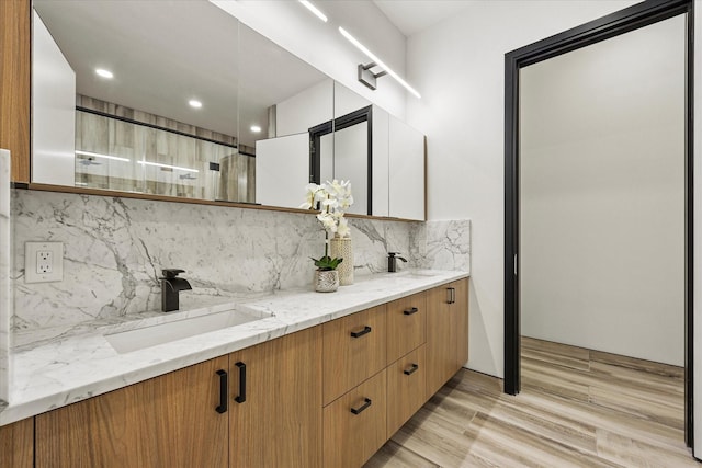 bathroom featuring decorative backsplash, vanity, and wood-type flooring