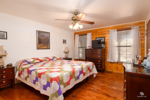 bedroom with hardwood / wood-style floors, crown molding, and wood walls