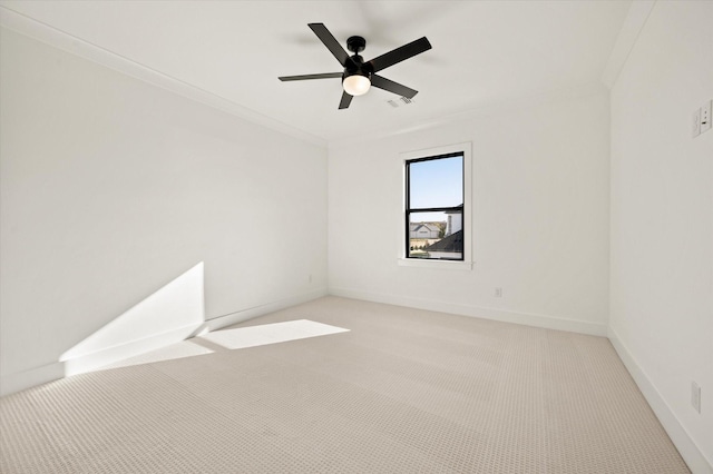 spare room featuring ceiling fan, light colored carpet, and ornamental molding