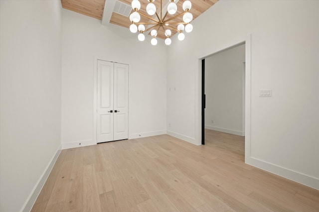 unfurnished room with beam ceiling, an inviting chandelier, wooden ceiling, and light wood-type flooring