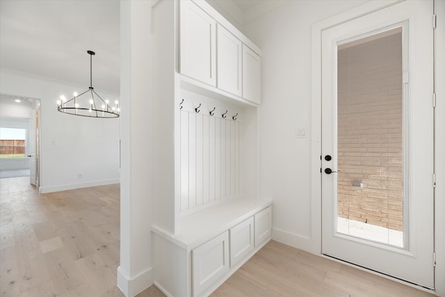 mudroom with light hardwood / wood-style flooring, ornamental molding, and a notable chandelier