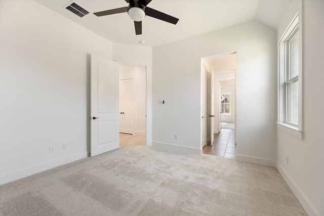 unfurnished bedroom featuring ceiling fan, light carpet, and vaulted ceiling