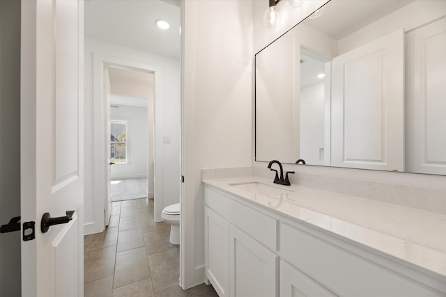 bathroom featuring tile patterned floors, vanity, and toilet