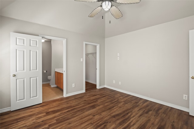 unfurnished bedroom featuring ceiling fan, dark hardwood / wood-style flooring, a spacious closet, and a closet