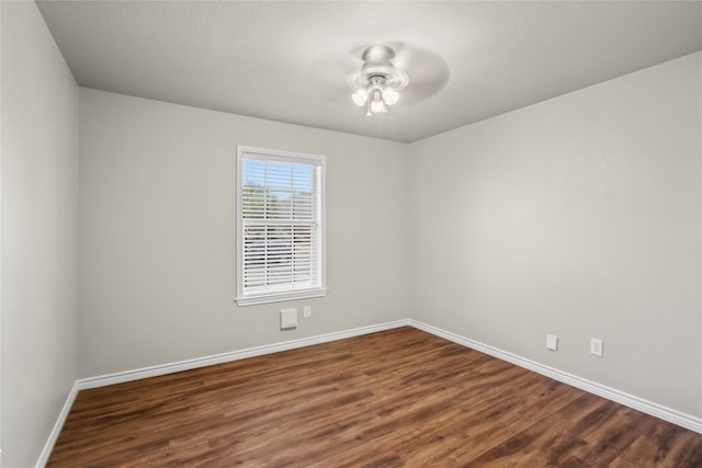 empty room with ceiling fan and dark wood-type flooring