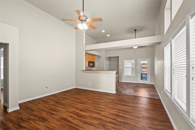 unfurnished living room featuring ceiling fan, dark hardwood / wood-style flooring, sink, and high vaulted ceiling