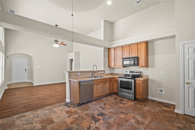 kitchen featuring high vaulted ceiling, sink, ceiling fan, dark hardwood / wood-style flooring, and stainless steel appliances