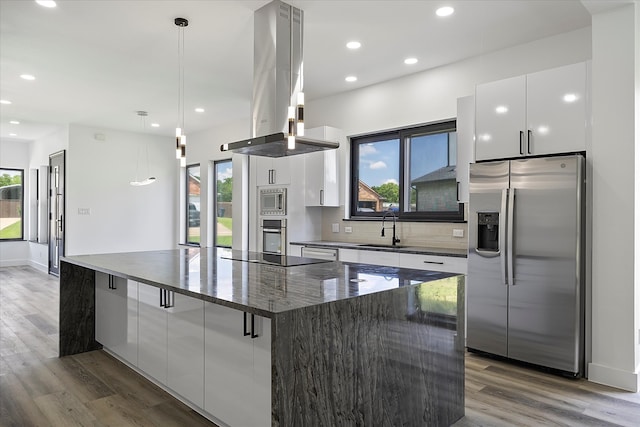 kitchen with pendant lighting, sink, appliances with stainless steel finishes, white cabinetry, and island exhaust hood