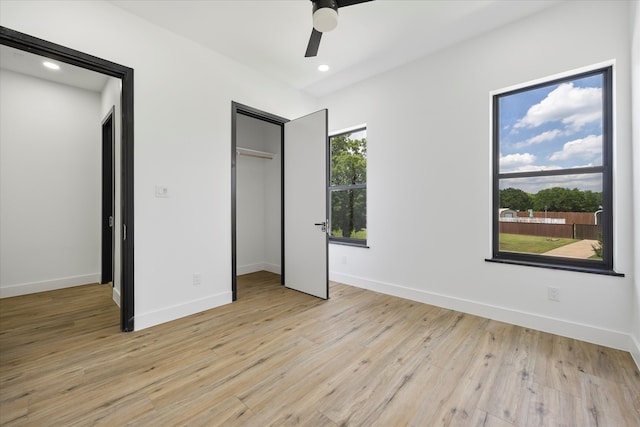 unfurnished bedroom featuring ceiling fan, light wood-type flooring, and a closet