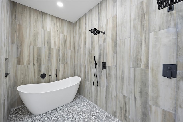 bathroom with tile walls and plus walk in shower