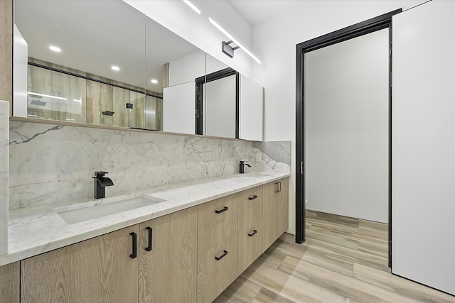 bathroom with tasteful backsplash, vanity, and hardwood / wood-style floors