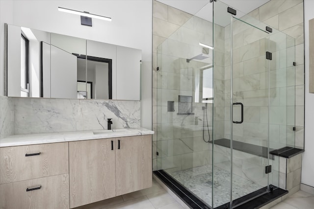 bathroom featuring tasteful backsplash, an enclosed shower, and vanity