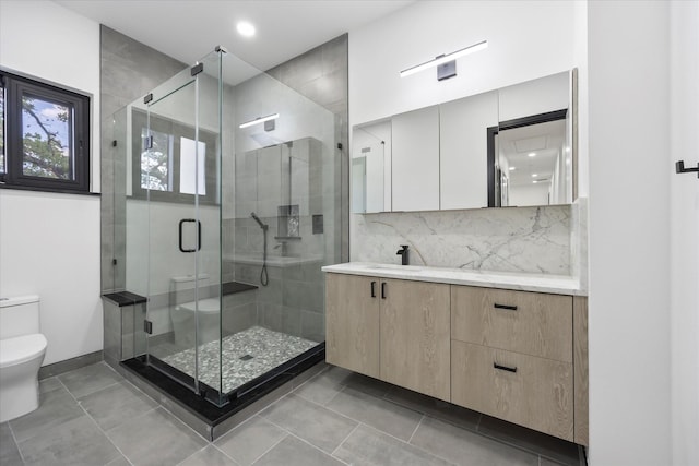 bathroom with a shower with shower door, decorative backsplash, vanity, toilet, and tile patterned floors