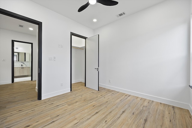 unfurnished bedroom with ceiling fan, light hardwood / wood-style floors, and a closet