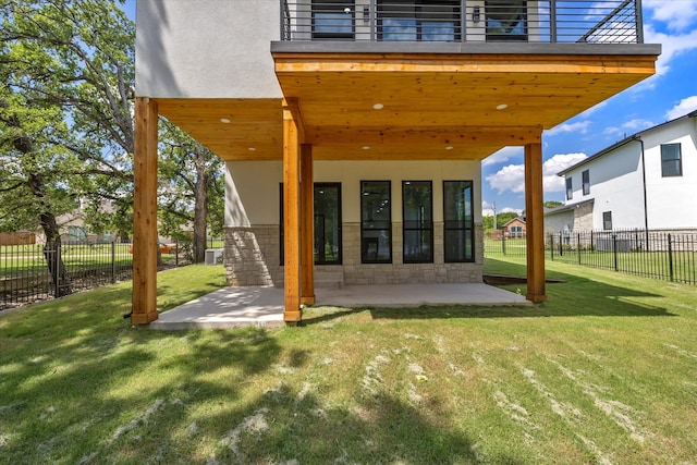 back of house with a balcony, a yard, and a patio area