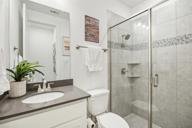 bathroom featuring vanity, a shower with shower door, and toilet