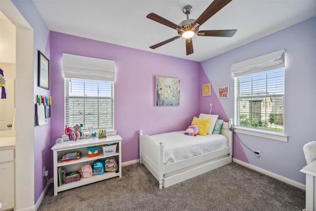 carpeted bedroom with ensuite bathroom and ceiling fan