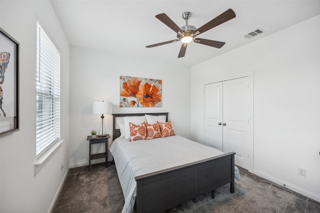 bedroom with ceiling fan, a closet, and dark colored carpet