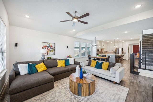 living room with hardwood / wood-style floors, vaulted ceiling, and ceiling fan