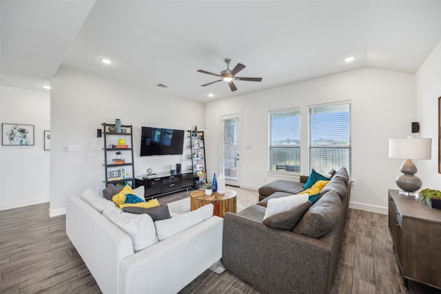 living room with ceiling fan, dark wood-type flooring, and vaulted ceiling